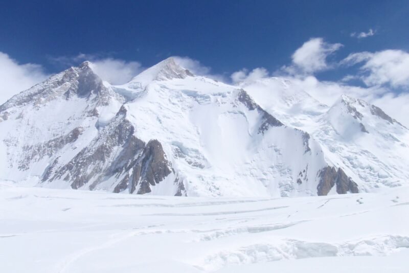 The snow basin below the face, ski and foot tracks crossing it