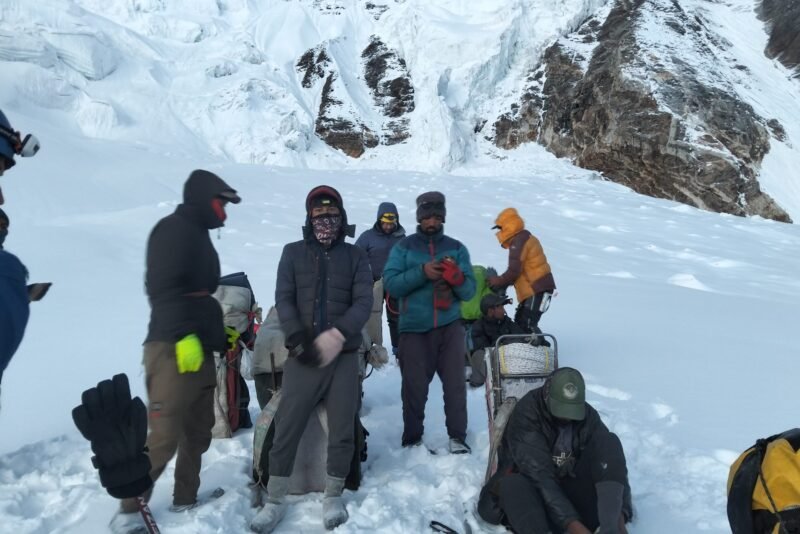 The party gathered on the ice with packs down, sorting kit before moving on
