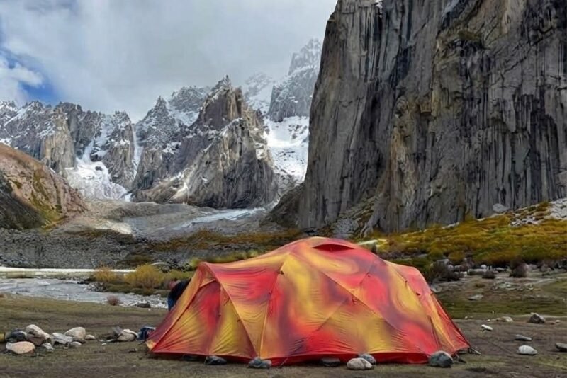 A tent pitched on the valley floor below the big walls
