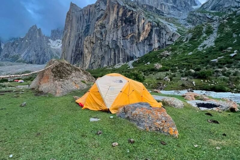 Tents on grass beside the stream under the Nangma walls